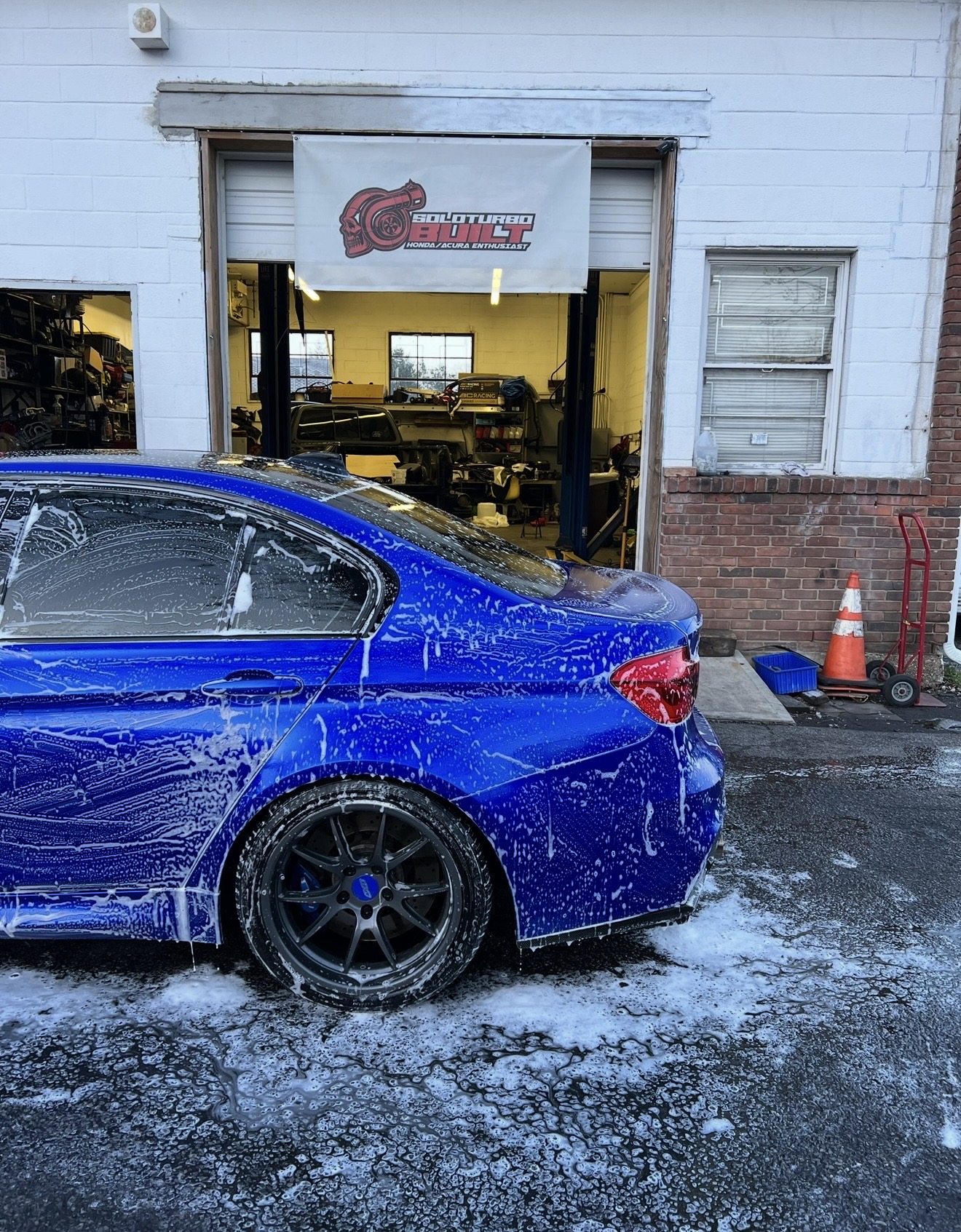 Foam-washed BMW outside SoloTurbo Built shop